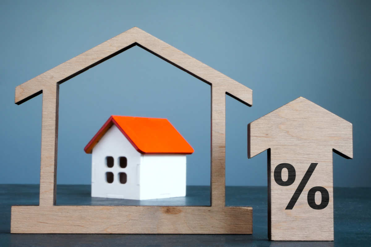 House model, arrow and percent sign as mortgage rates concept.